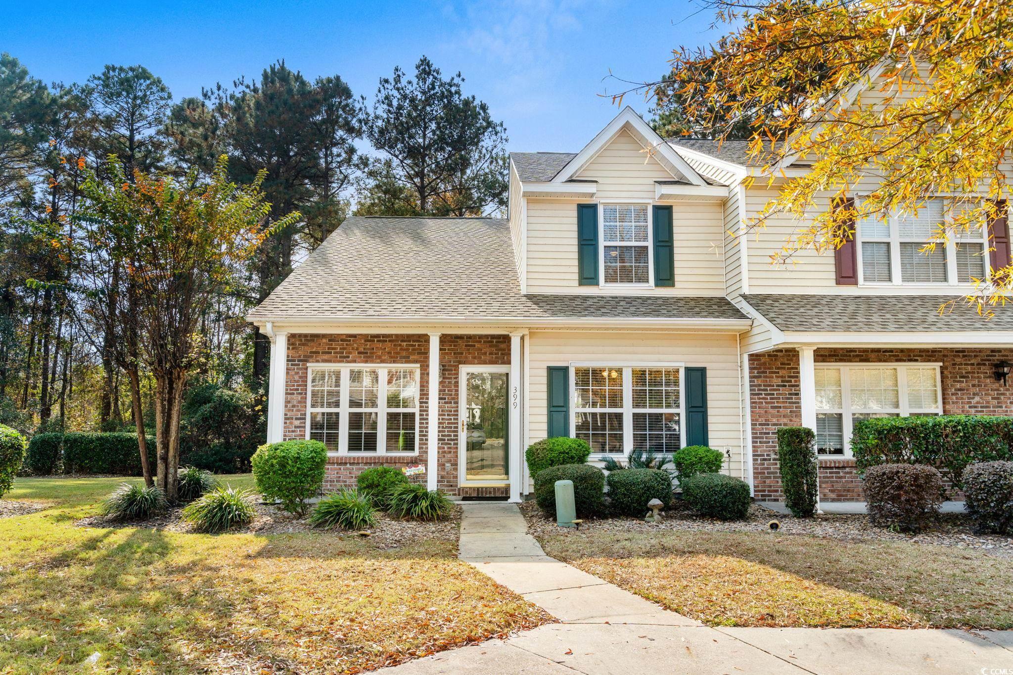 399 Seabert Road, Unit 209 Myrtle Beach, SC 29579 - Photo 2 of 40 Traditional-style home featuring covered porch, a front yard, brick siding, and roof with shingles