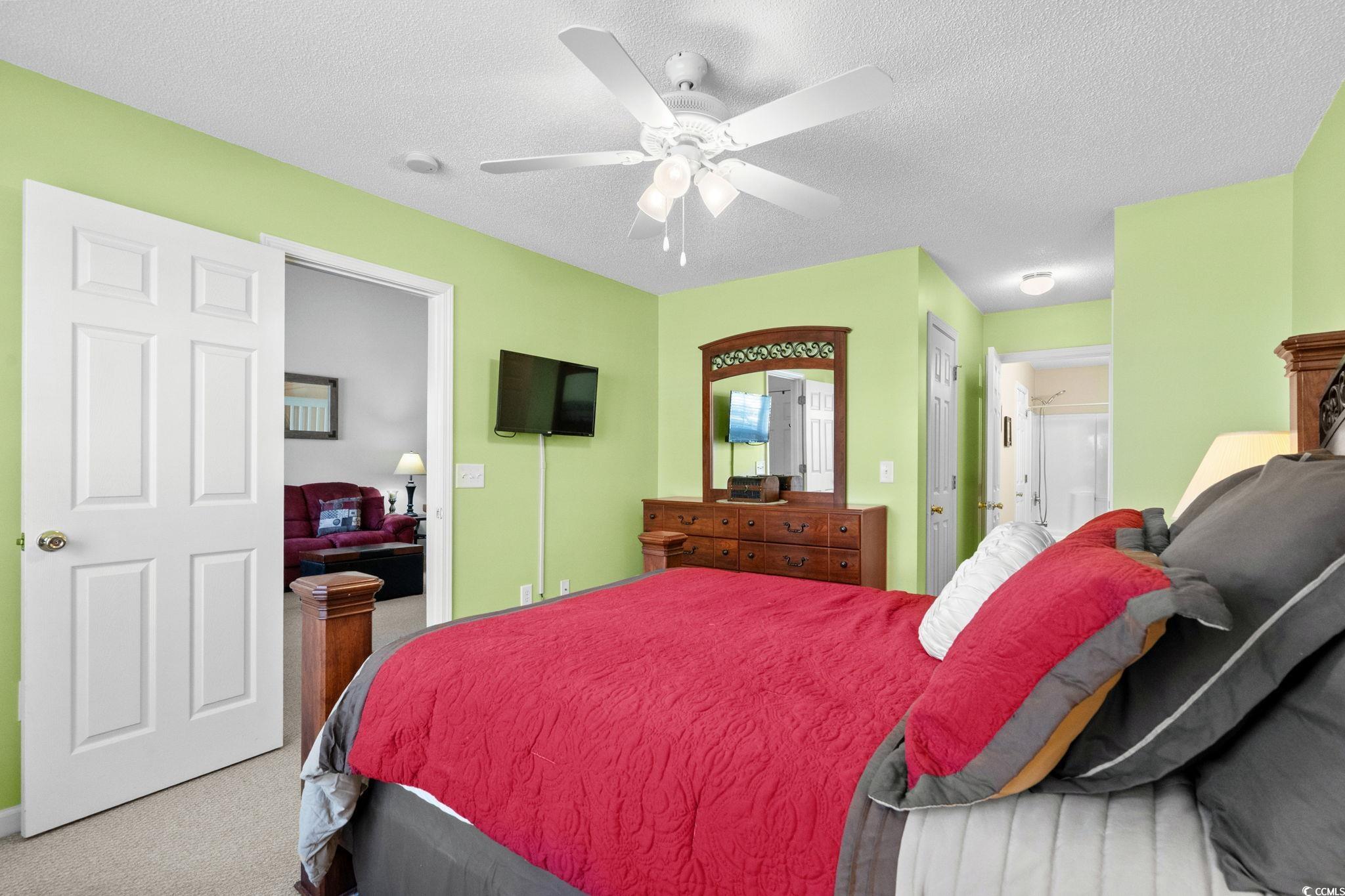 399 Seabert Road, Unit 209 Myrtle Beach, SC 29579 - Photo 27 of 40 Bedroom with carpet flooring, a textured ceiling, ensuite bathroom, and ceiling fan