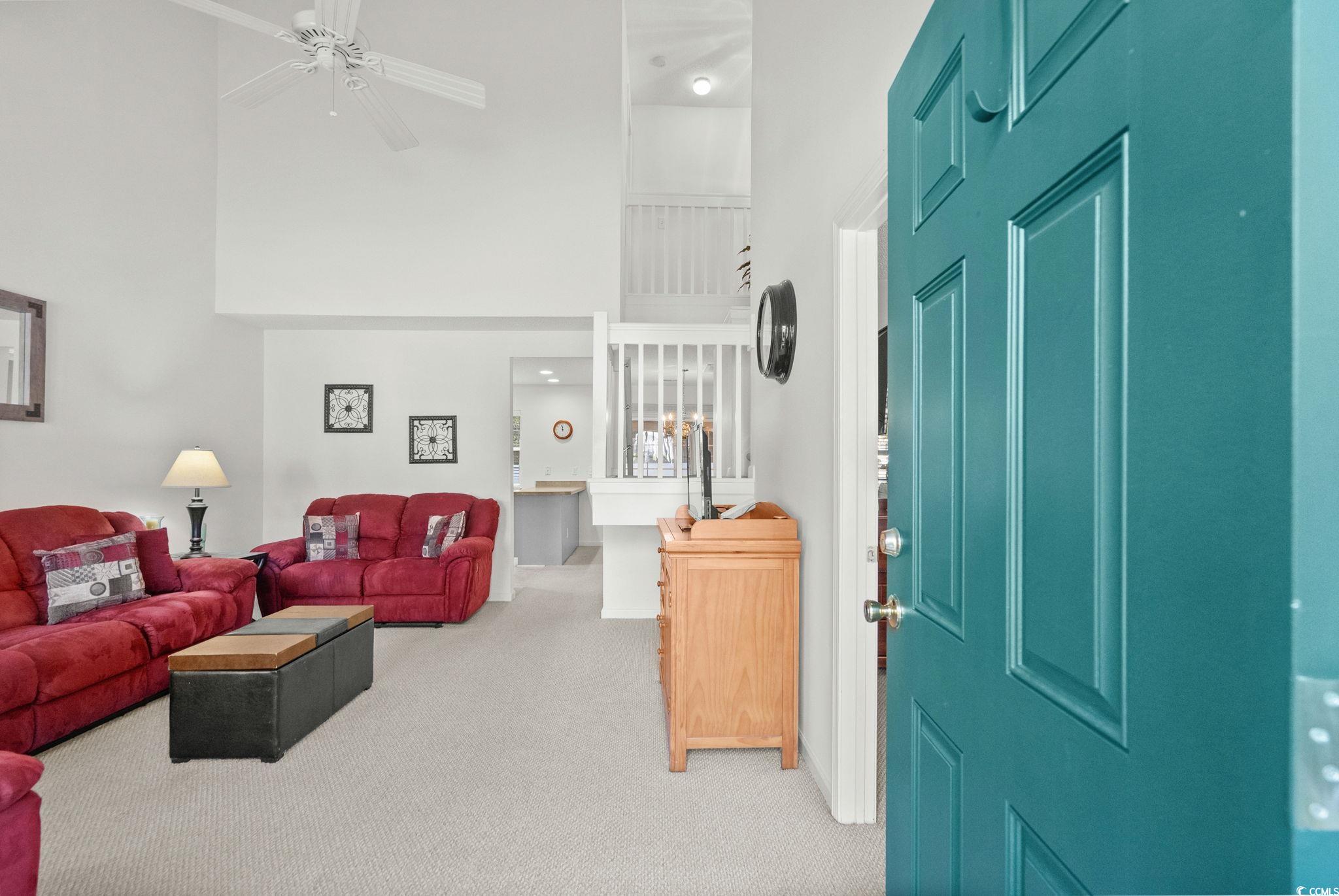 399 Seabert Road, Unit 209 Myrtle Beach, SC 29579 - Photo 5 of 40 Carpeted living area featuring a ceiling fan and a towering ceiling