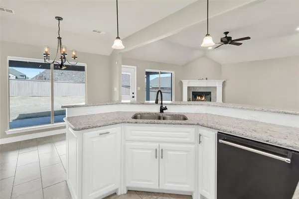 a kitchen with granite countertop a sink and chandelier