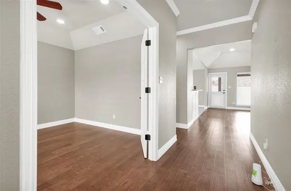 a view of a hallway with wooden floor and staircase