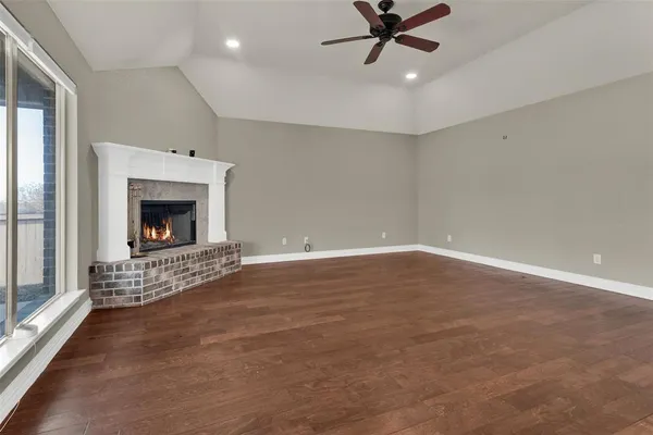 an empty room with ceiling fan and window
