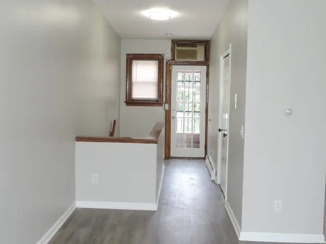 a view of a livingroom with wooden floor and a window