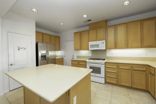 a kitchen with stainless steel appliances granite countertop a sink a stove and a refrigerator