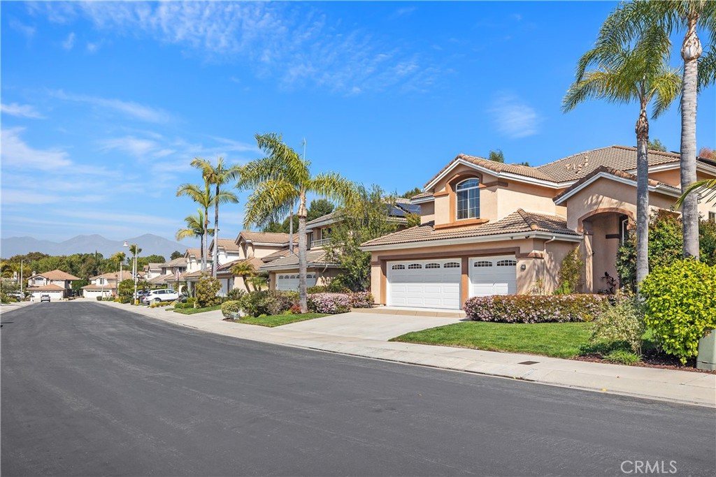 27 Hawk Hill Mission Viejo, CA 92692 - Photo 4 of 48 a front view of a house with a garden and a yard