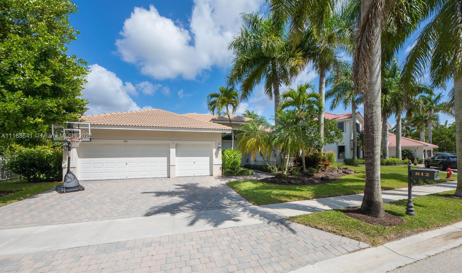 812 Regal Cove Road Weston, FL 33327 - Photo 12 of 64 a view of a house with a yard and palm trees