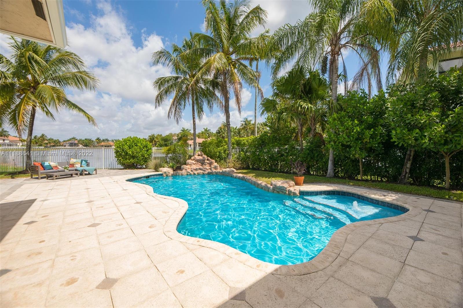 812 Regal Cove Road Weston, FL 33327 - Photo 2 of 64 a view of swimming pool with a garden