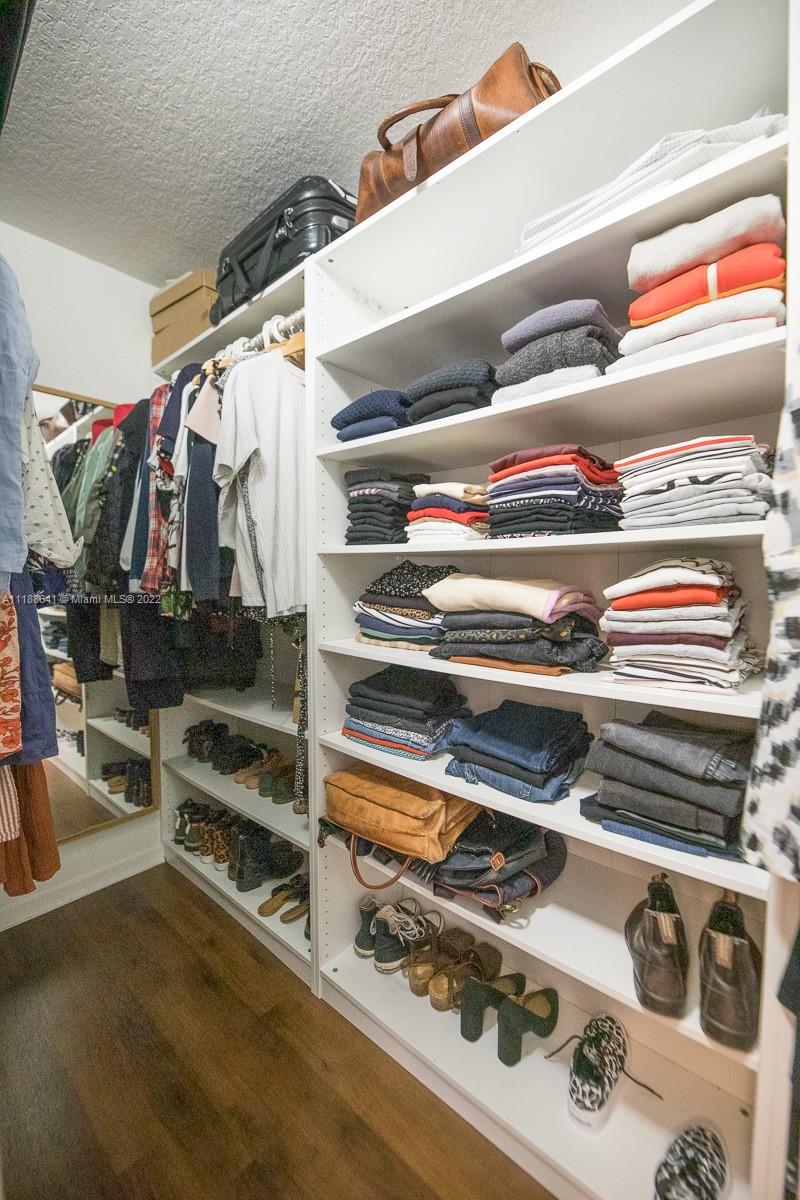 812 Regal Cove Road Weston, FL 33327 - Photo 50 of 64 a view of walk in closet with clothes and shoes