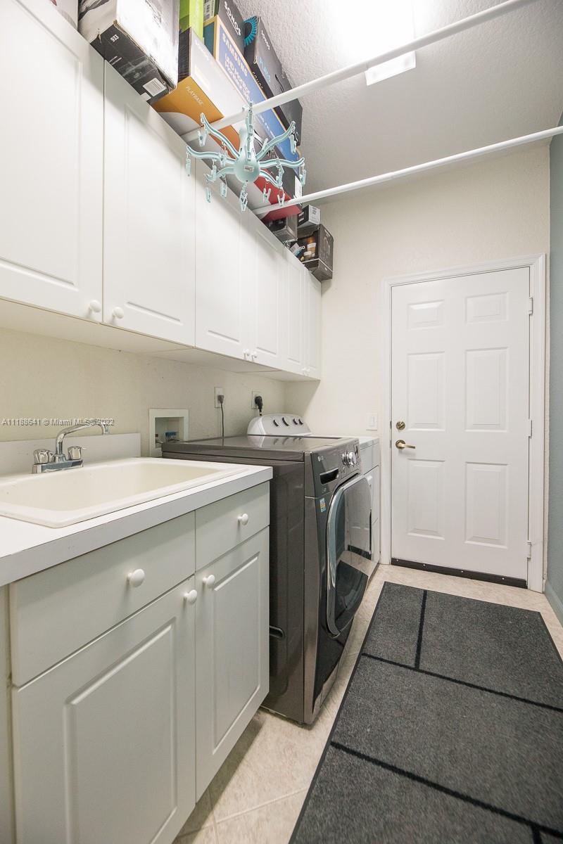 812 Regal Cove Road Weston, FL 33327 - Photo 62 of 64 a utility room with cabinets and washer dryer
