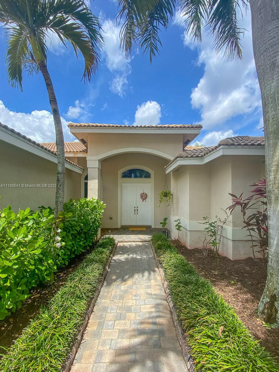 812 Regal Cove Road Weston, FL 33327 - Photo 9 of 64 a front view of a house with a yard
