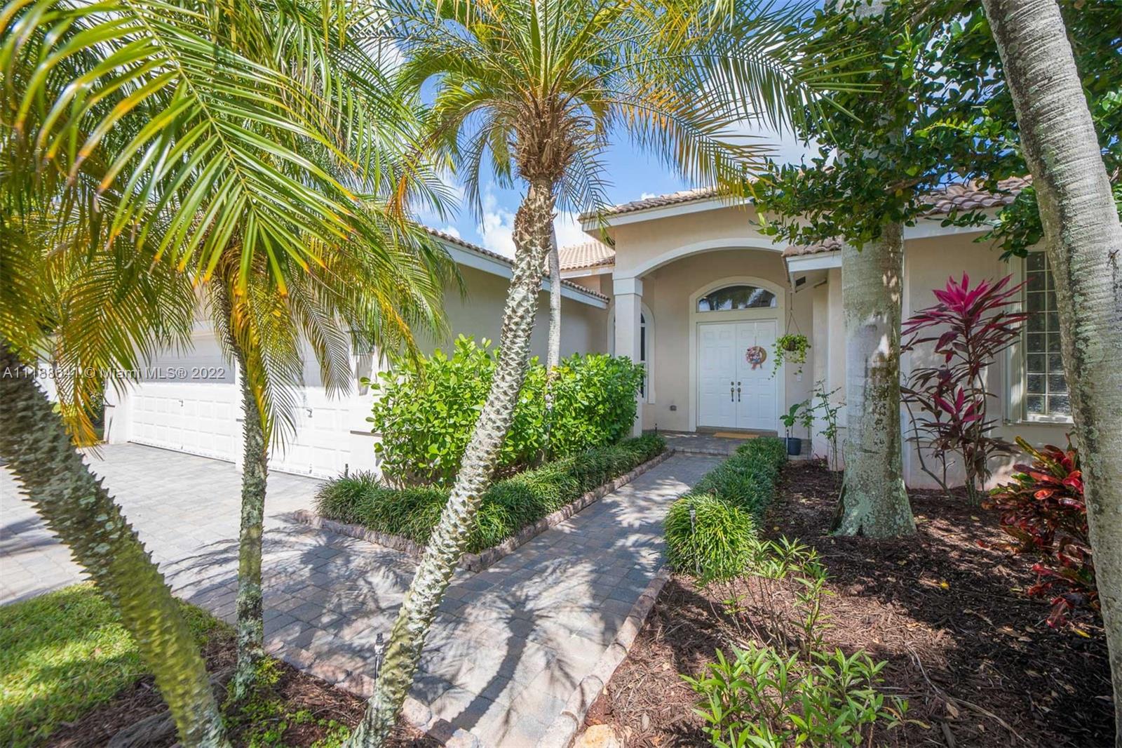812 Regal Cove Road Weston, FL 33327 - Photo 10 of 64 a front view of a house with a yard