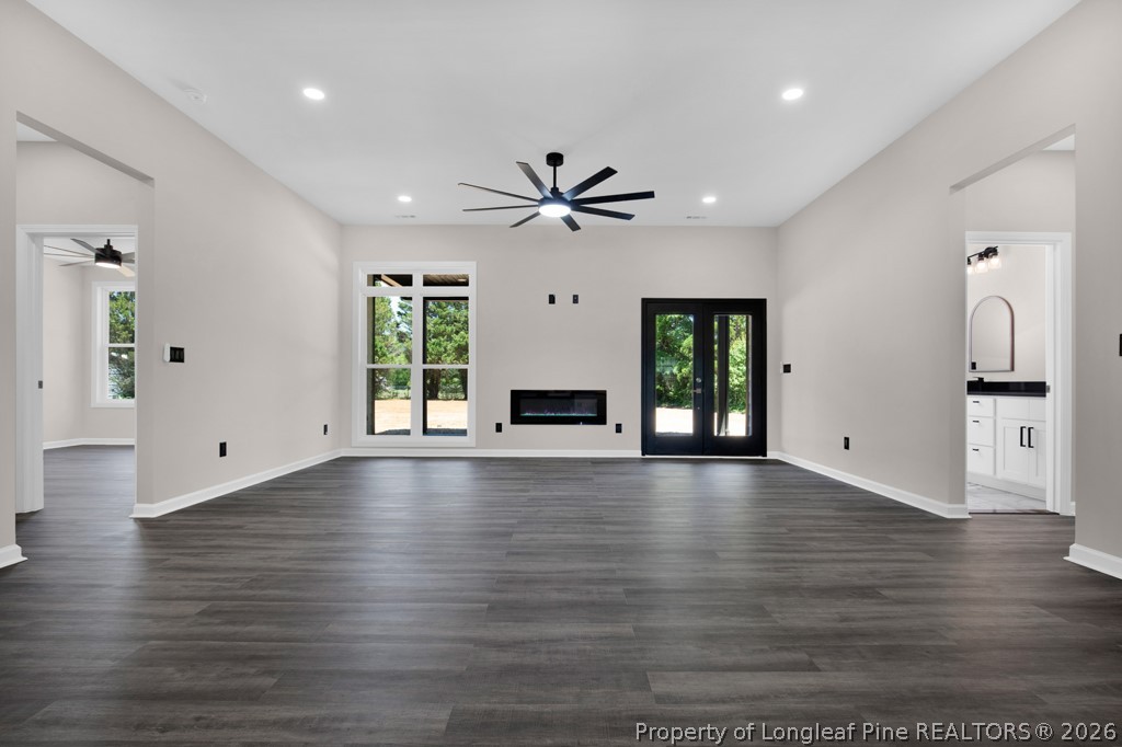 3025 Old Stage Road South Erwin, NC 28339 - Photo 9 of 50 an empty room with wooden floor a ceiling fan and windows