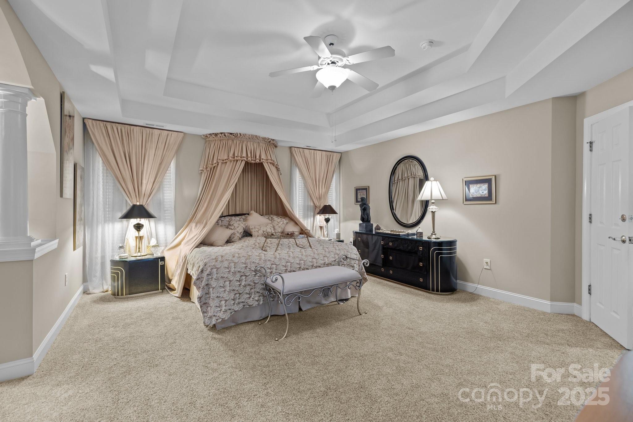 204 Limerick Drive Matthews, NC 28104 - Photo 22 of 44 a spacious bedroom with a bed and a chandelier