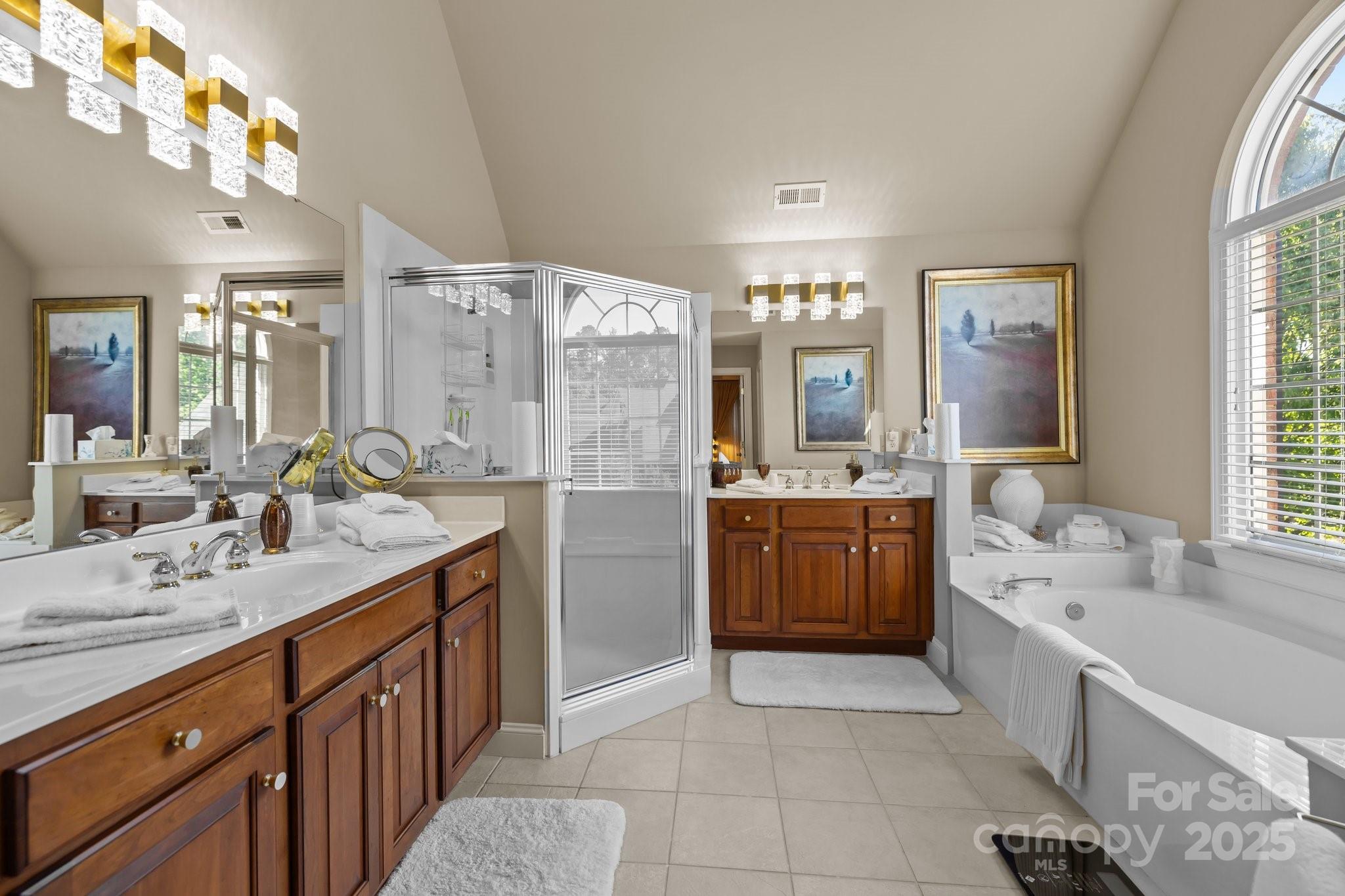 204 Limerick Drive Matthews, NC 28104 - Photo 25 of 44 a large bathroom with a double vanity sink a large mirror and a bathtub