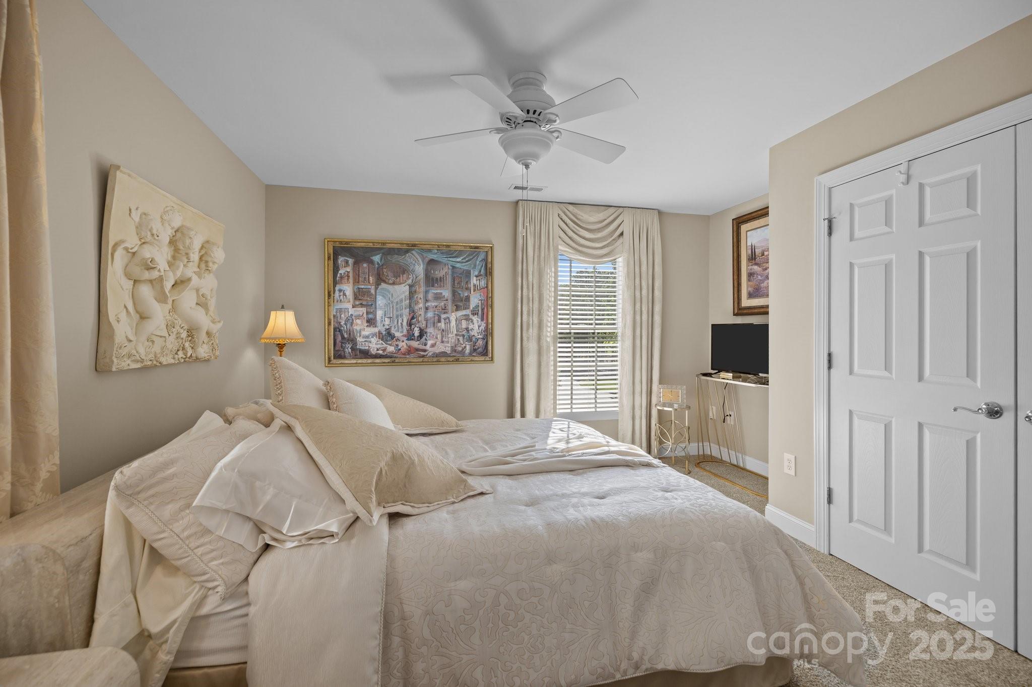 204 Limerick Drive Matthews, NC 28104 - Photo 30 of 44 a bedroom with a large bed and a chandelier