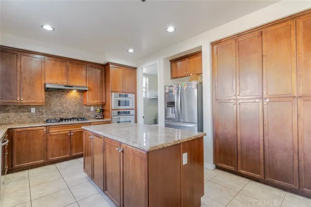 a kitchen with stainless steel appliances granite countertop a refrigerator a sink and dishwasher