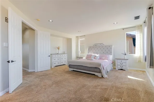 a spacious bedroom with a bed and a cabinets