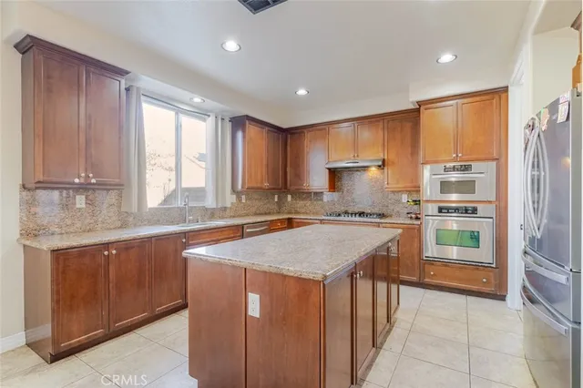 a kitchen with stainless steel appliances granite countertop a sink counter space cabinets and a large window