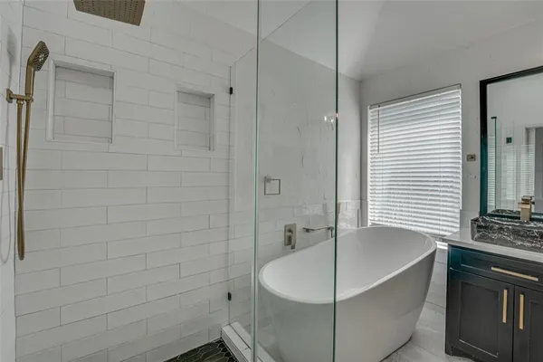 a spacious bathroom with a double vanity sink a large mirror and a bathtub