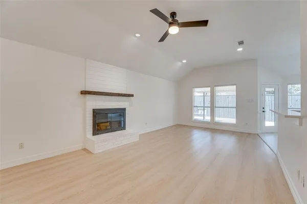 an empty room with windows and a fireplace