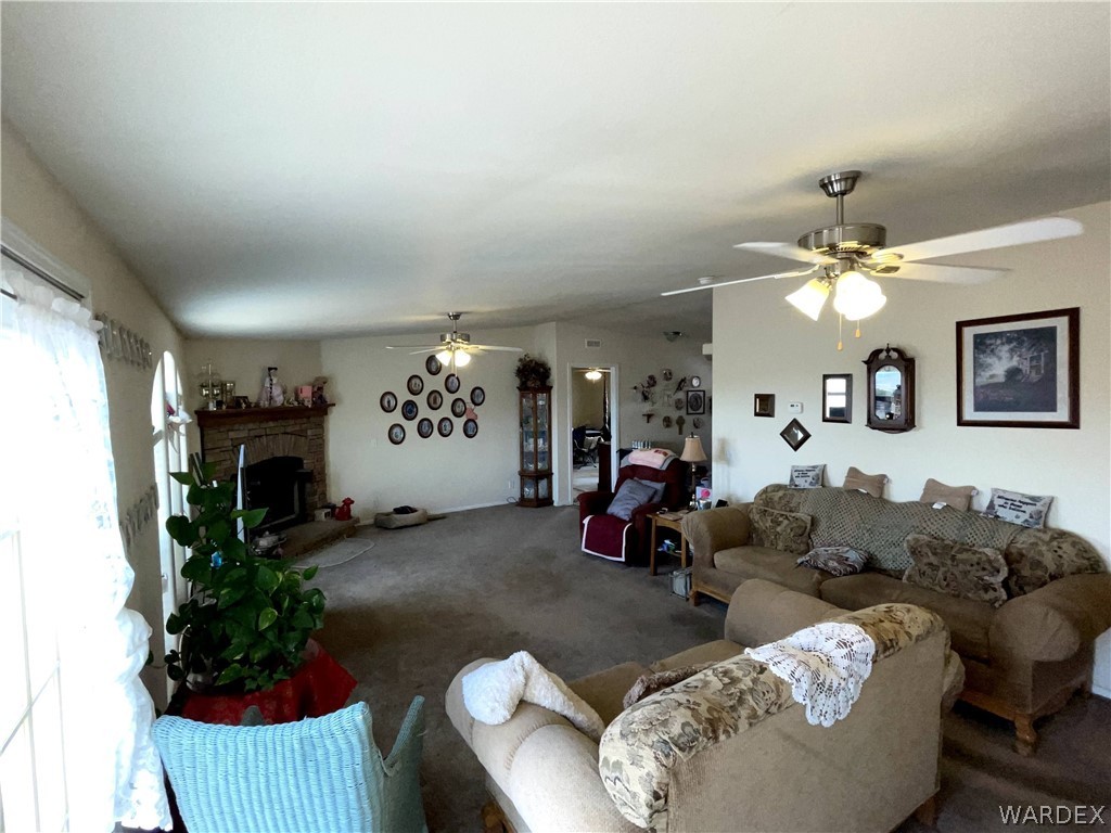 10551 East Blake Ranch Road Kingman, AZ 86401 - Photo 14 of 50 a living room with furniture a fireplace and a chandelier
