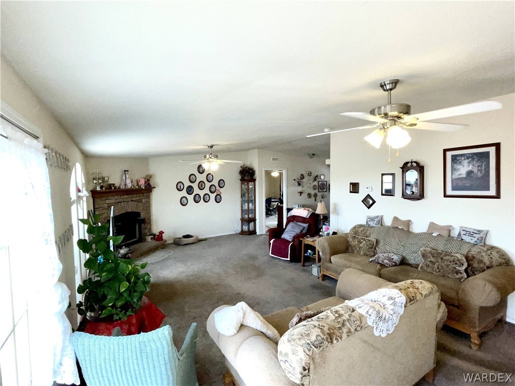 10551 East Blake Ranch Road Kingman, AZ 86401 - Photo 15 of 50 a living room with furniture flower pot and a fireplace