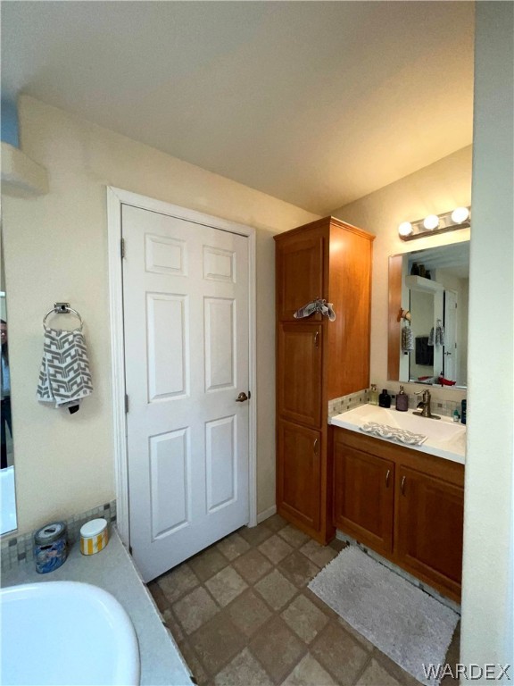 10551 East Blake Ranch Road Kingman, AZ 86401 - Photo 18 of 50 a spacious bathroom with a granite countertop sink and a mirror
