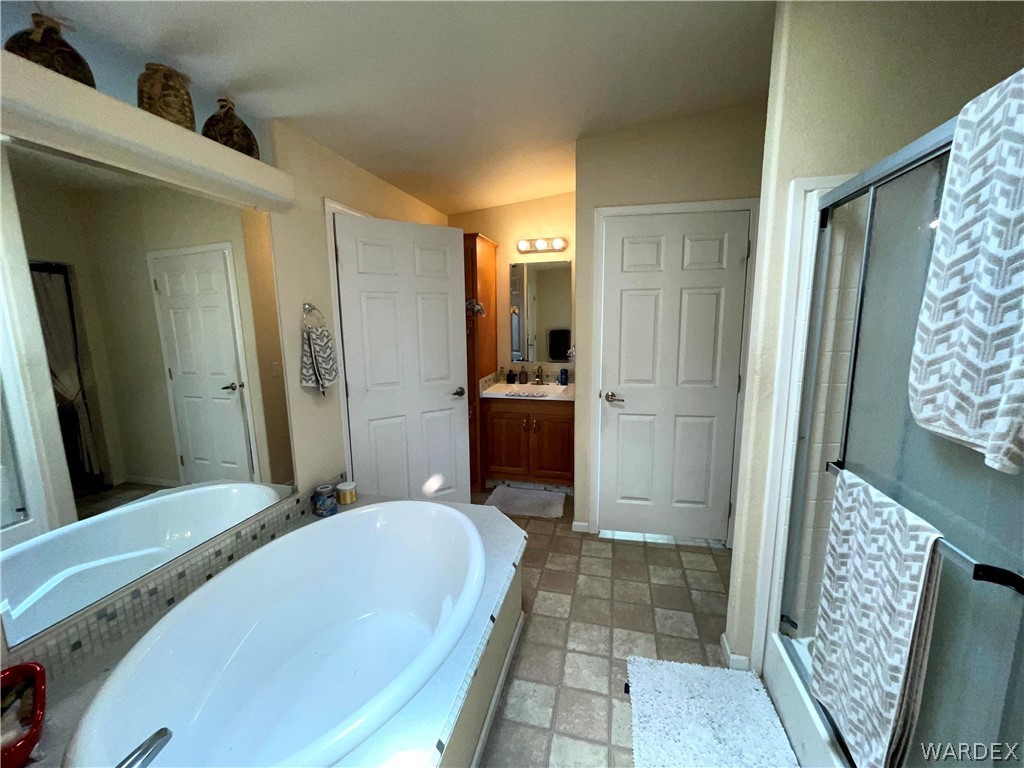 10551 East Blake Ranch Road Kingman, AZ 86401 - Photo 19 of 50 a bathroom with a bathtub shower sink and mirror