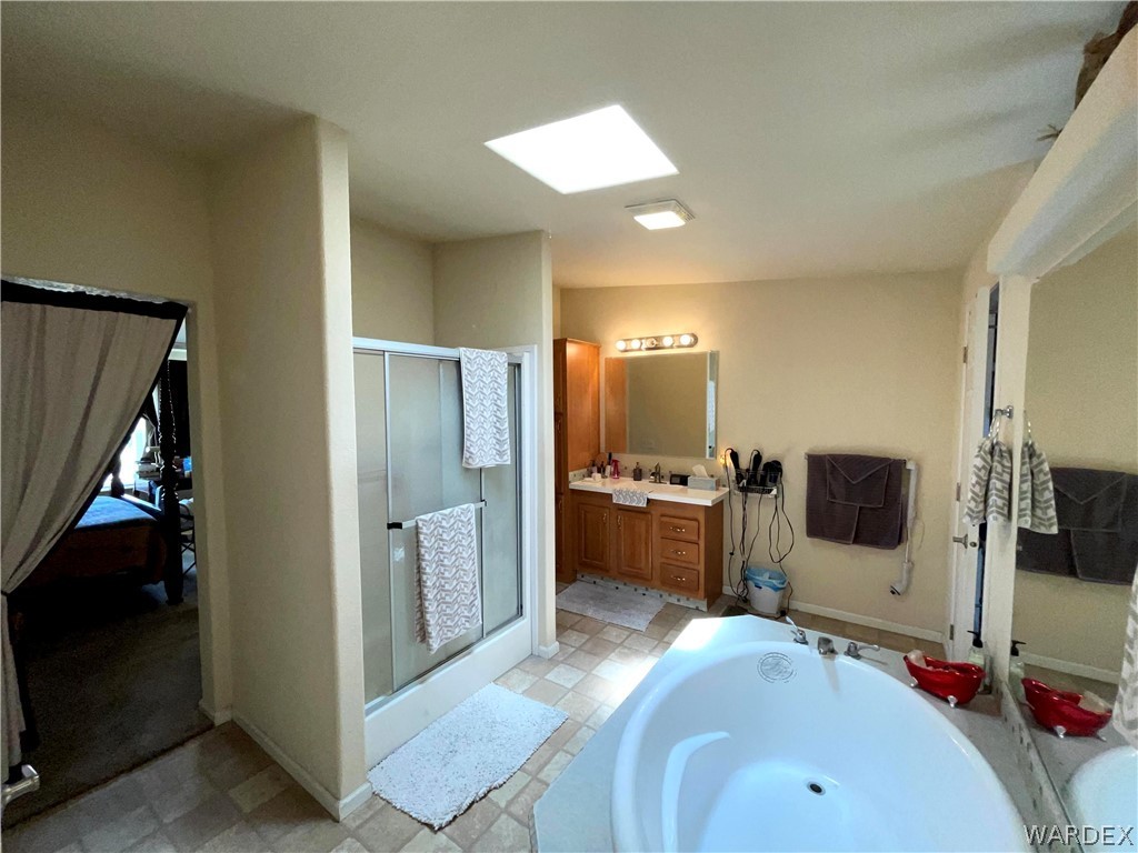 10551 East Blake Ranch Road Kingman, AZ 86401 - Photo 20 of 50 a spacious bathroom with a tub and a double vanity sink
