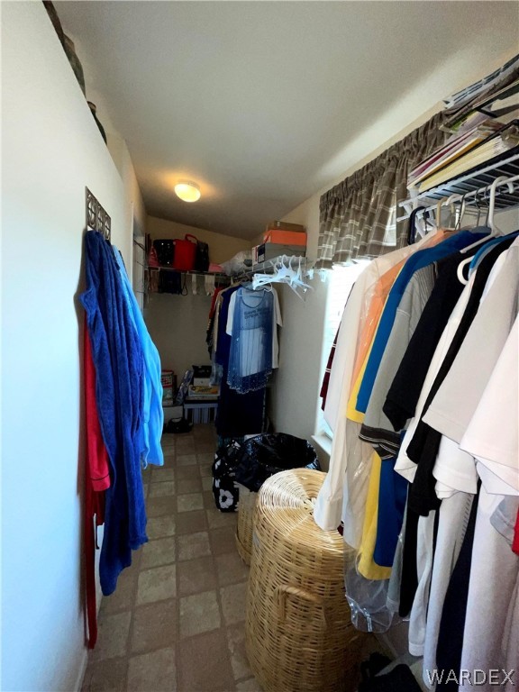 10551 East Blake Ranch Road Kingman, AZ 86401 - Photo 21 of 50 a view of walk in closet with clothes and shoes