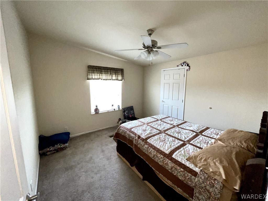 10551 East Blake Ranch Road Kingman, AZ 86401 - Photo 23 of 50 a bedroom with a bed and a window
