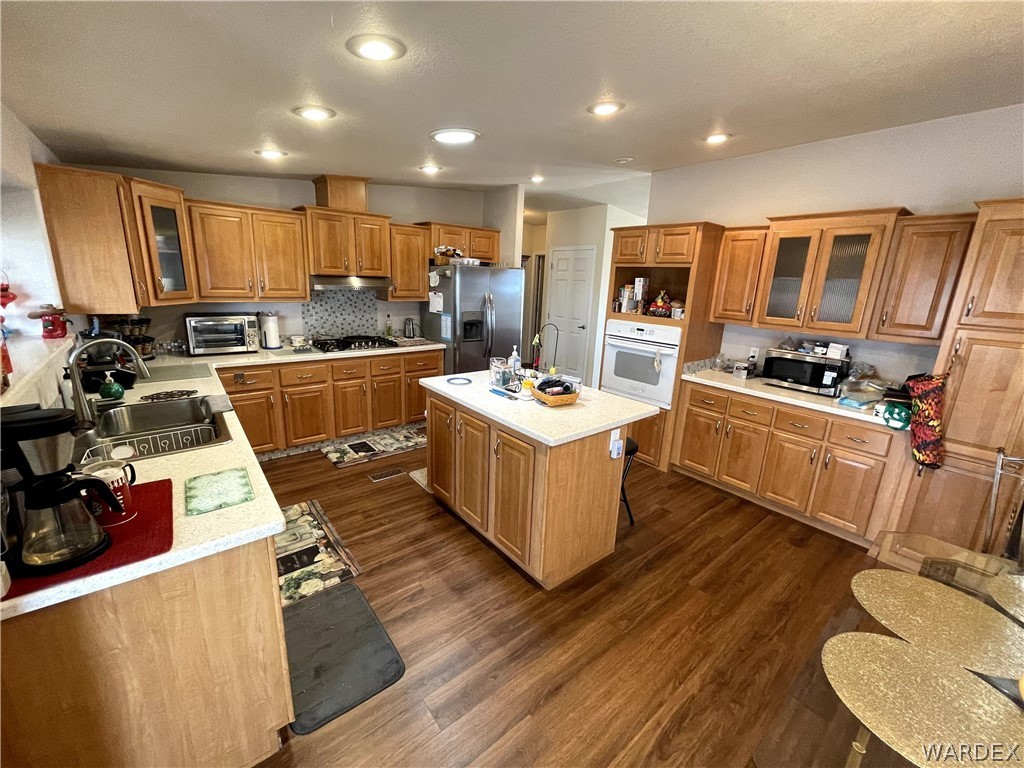 10551 East Blake Ranch Road Kingman, AZ 86401 - Photo 5 of 50 a large kitchen with stainless steel appliances kitchen island granite countertop a stove refrigerator and a view of living room
