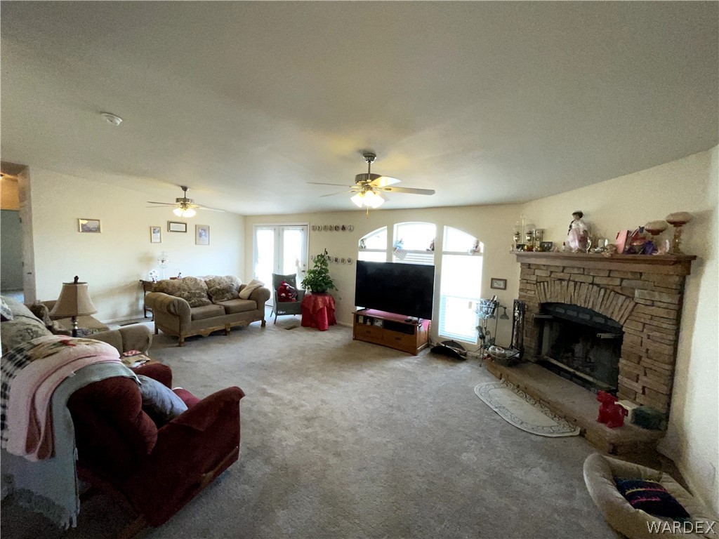 10551 East Blake Ranch Road Kingman, AZ 86401 - Photo 10 of 50 a living room with furniture a fireplace and a flat screen tv
