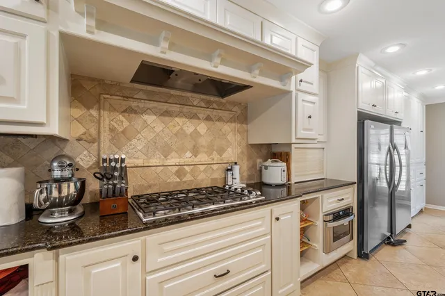 a kitchen with stainless steel appliances granite countertop a stove and a refrigerator