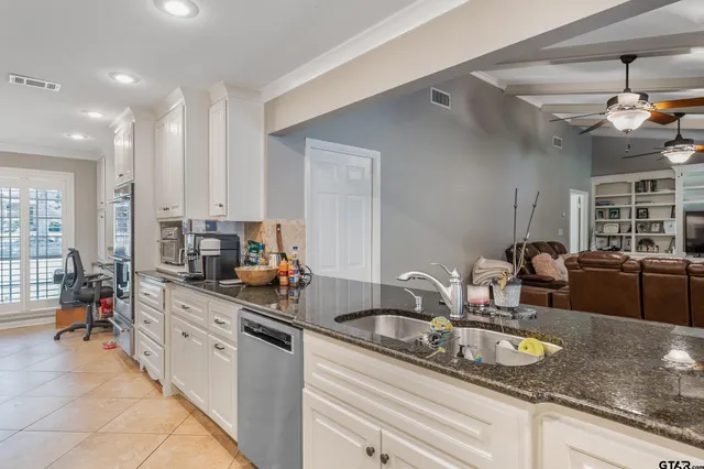 a kitchen with granite countertop a sink a counter top space appliances and cabinets