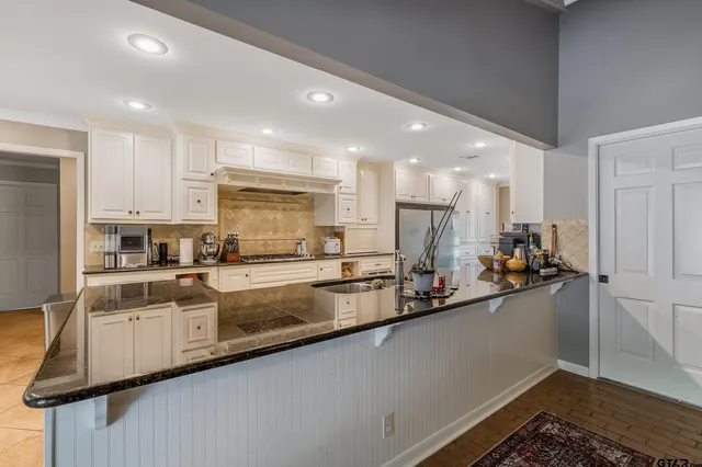 a view of a kitchen with kitchen island a sink stainless steel appliances and cabinets