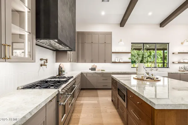 a bedroom with a white bed and dresser with wooden floor