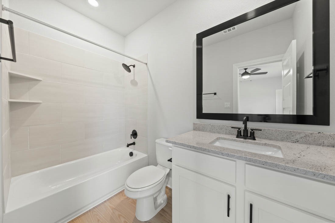 17109 Howdy Way Manor, TX 78653 - Photo 17 of 24 a bathroom with a granite countertop sink a toilet and a bathtub