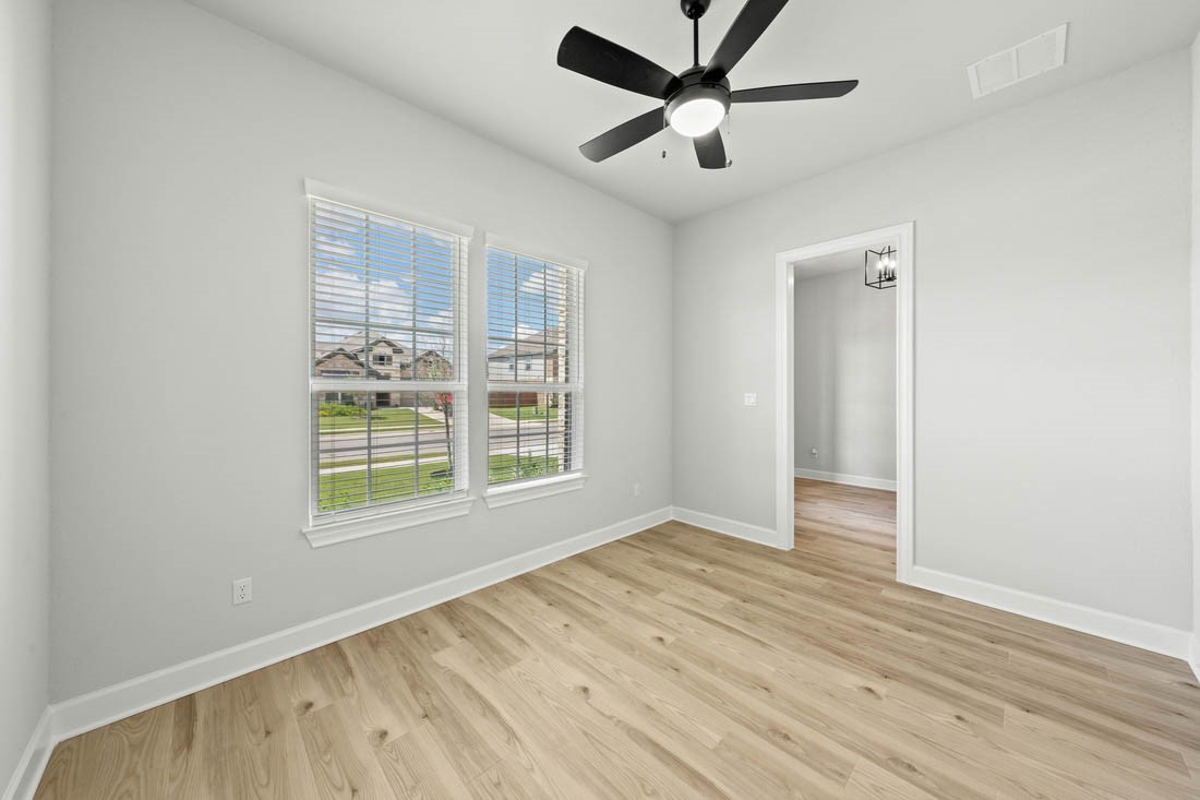 17109 Howdy Way Manor, TX 78653 - Photo 3 of 24 an empty room with wooden floor and windows