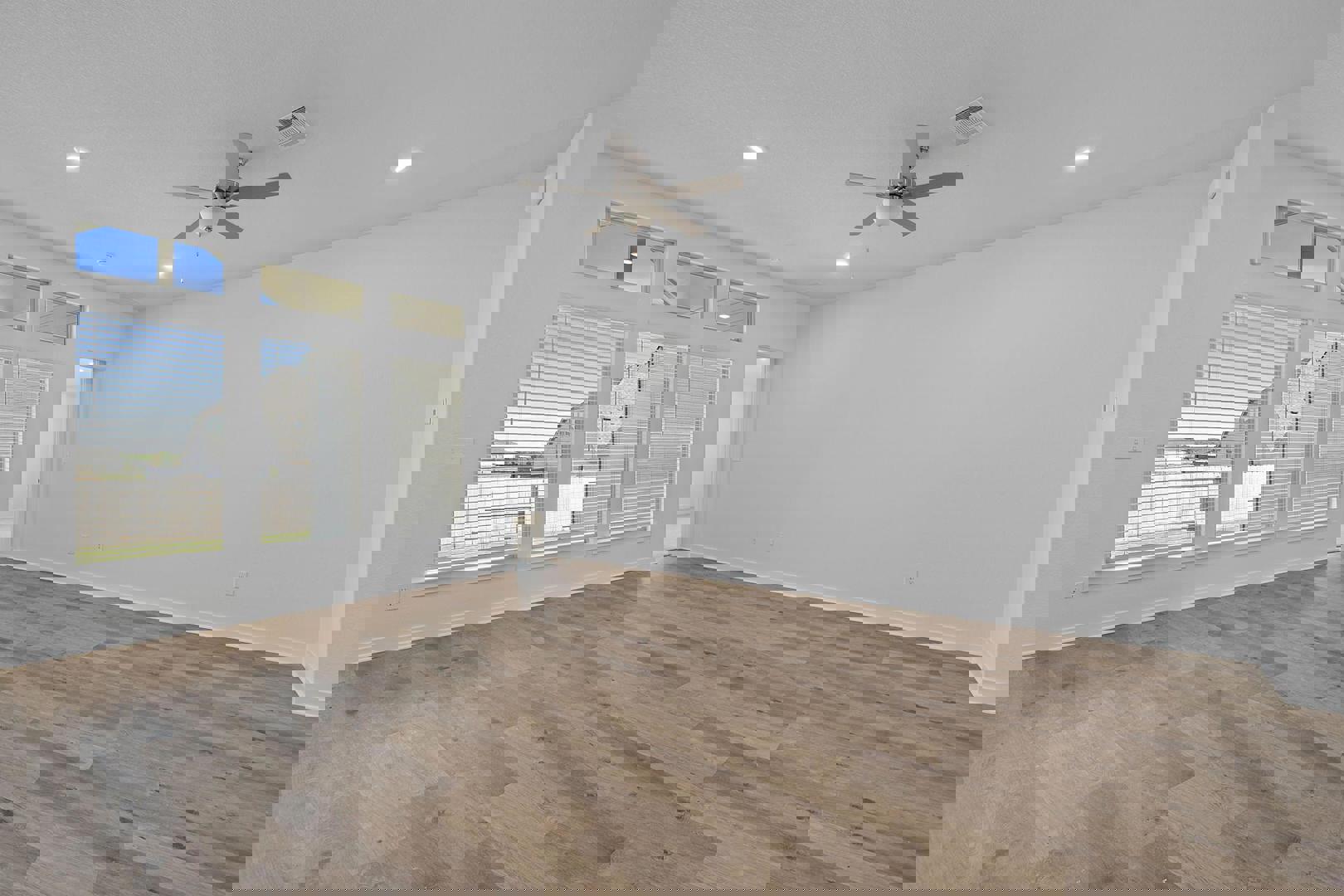 429 Brandywine Road Hutto, TX 78634 - Photo 9 of 28 an empty room with wooden floor fan and windows