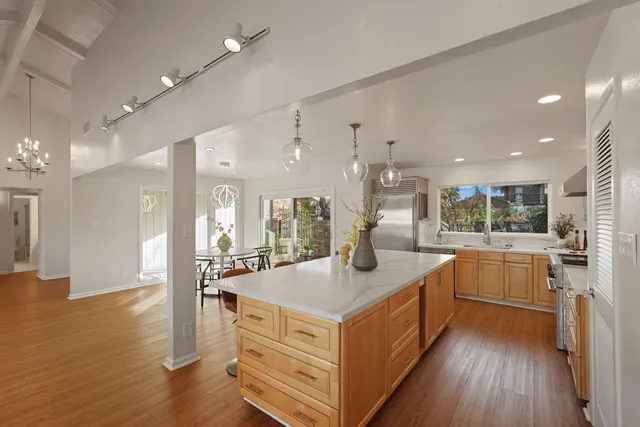 a kitchen with stainless steel appliances granite countertop a kitchen island a stove a cabinets a sink and a refrigerator