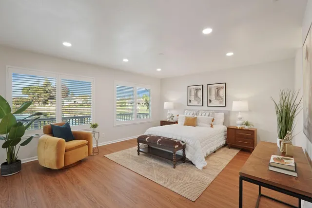 a bedroom with a large bed and a potted plant