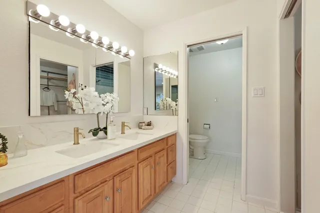 a bathroom with a sink a toilet and a mirror