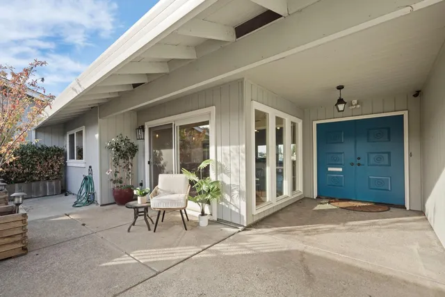 a view of a patio with couches and table and chairs and potted plants