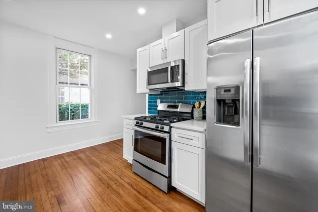 a kitchen with stainless steel appliances granite countertop a stove a refrigerator and a microwave