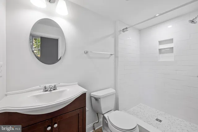 a bathroom with a sink a toilet and a mirror