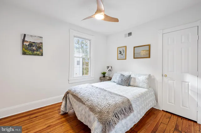 a bedroom with a bed and a wooden floor