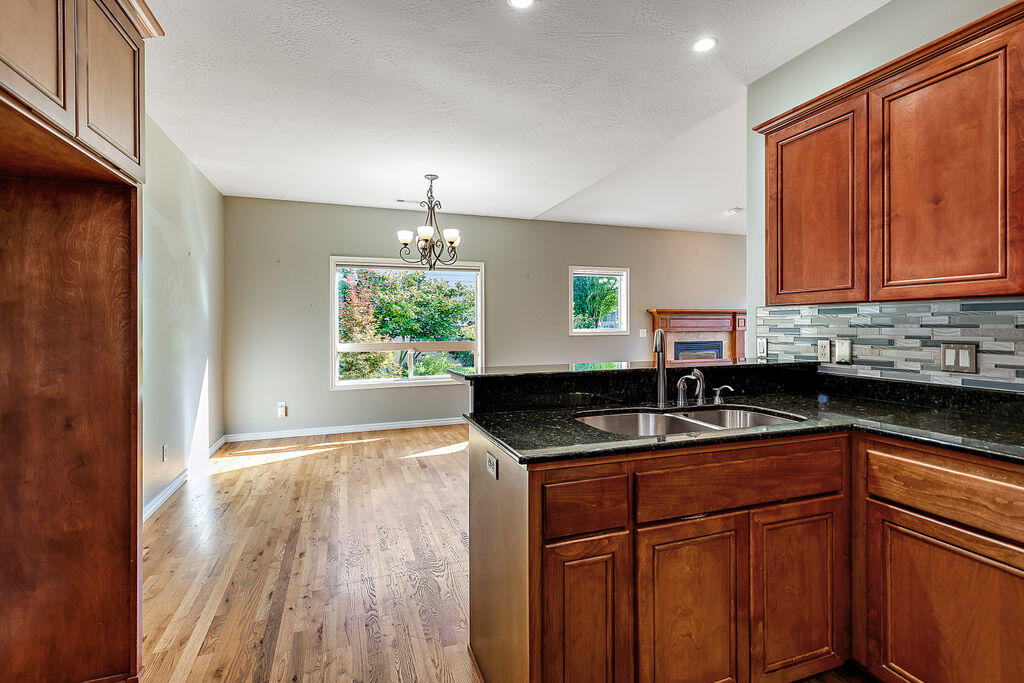 1034 Buck Point Street Central Point, OR 97502 - Photo 23 of 43 a kitchen with granite countertop cabinets sink and wooden floor