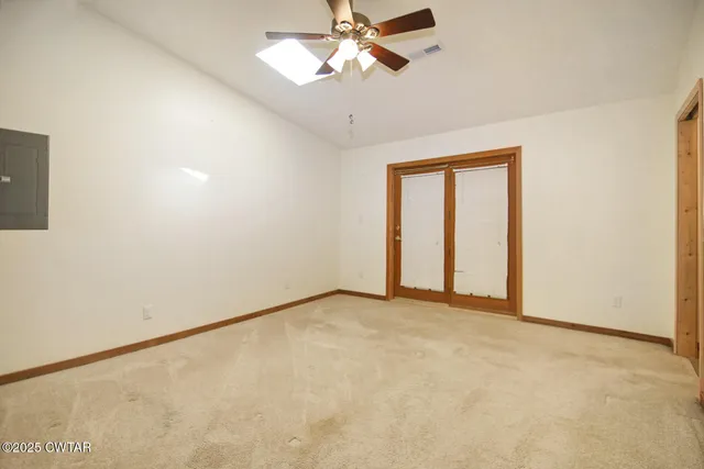 an empty room with fan and windows