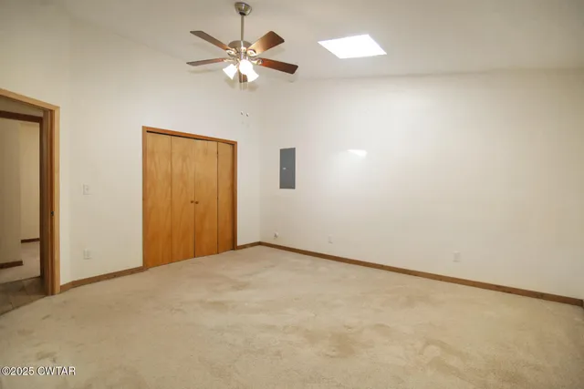 an empty room with a chandelier fan